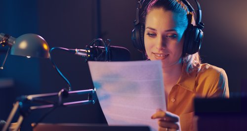 Professionelle Radiosprecherin verwendet vorbereitetes Skript am Mikrofon - Beispiel für hörfreundliche Textgestaltung